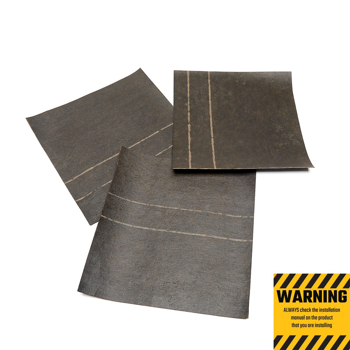 Three sheets of dark material are overlapping slightly. One sheet has white lines, suggesting a design for specific use, on a white background.