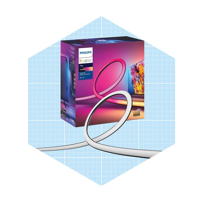 A Philips Hue Play light strip is coiled beside its colorful packaging, showcasing a vibrant lighting design suitable for enhancing home entertainment setups.