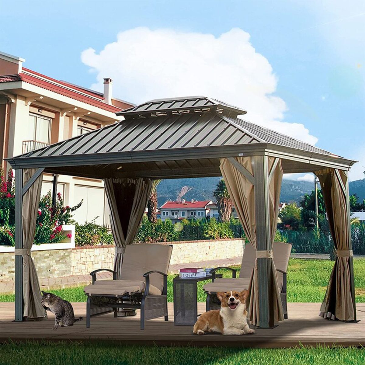 A gazebo stands in a backyard, containing two chairs and a small table, while a cat and a corgi sit nearby, surrounded by greenery and blue sky.