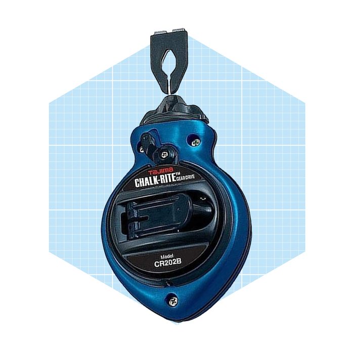 A chalk line reel is suspended, ready to mark straight lines, against a light blue grid background. The device is labeled with 