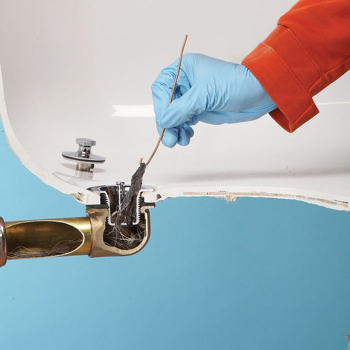 Clearing the hair from the drain with brass pin