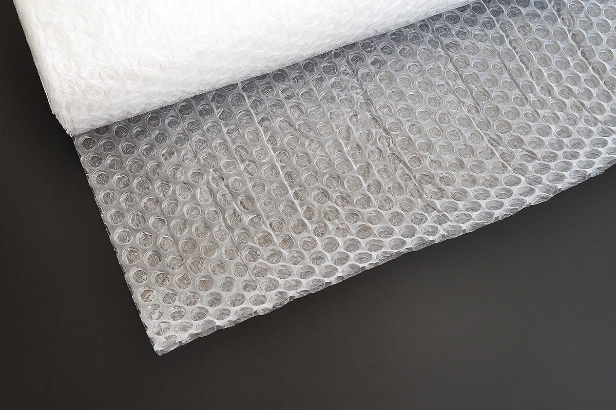 Transparent bubble wrap roll for packaging fragile items on black background